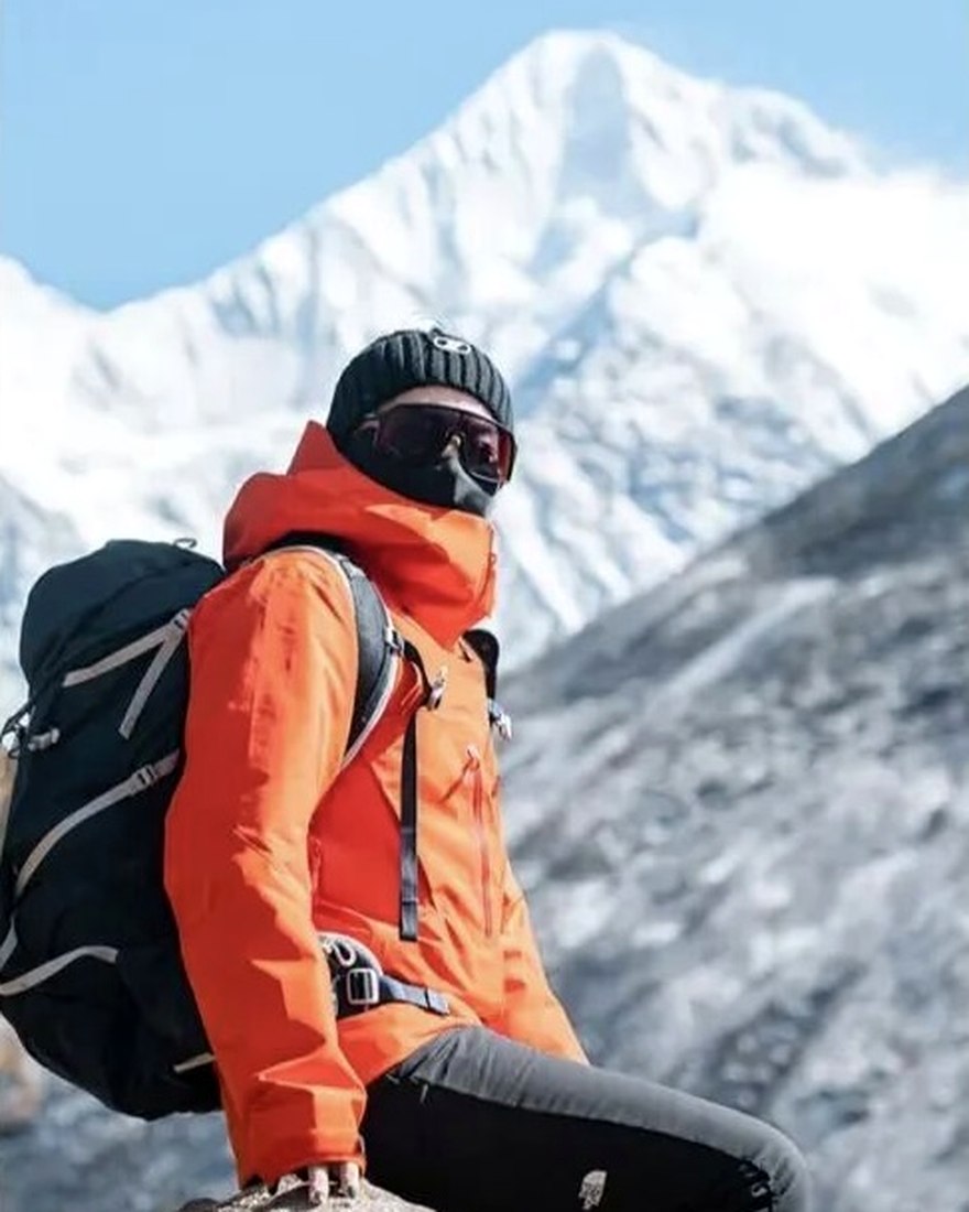 Jian, lead guide, beneath a snow-covered summit on a high pass in Yunnan