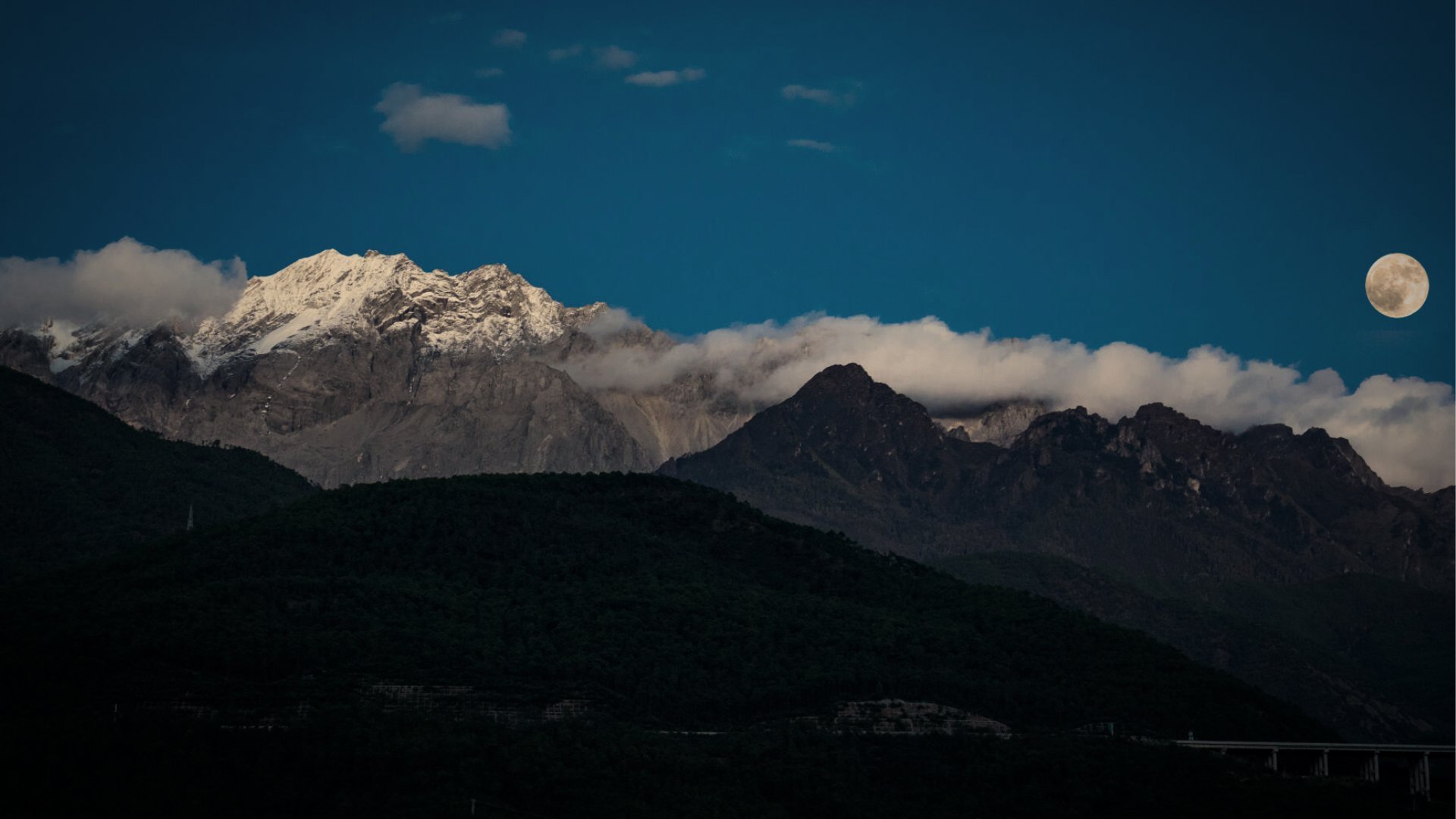 Full moon rising over a snow mountain