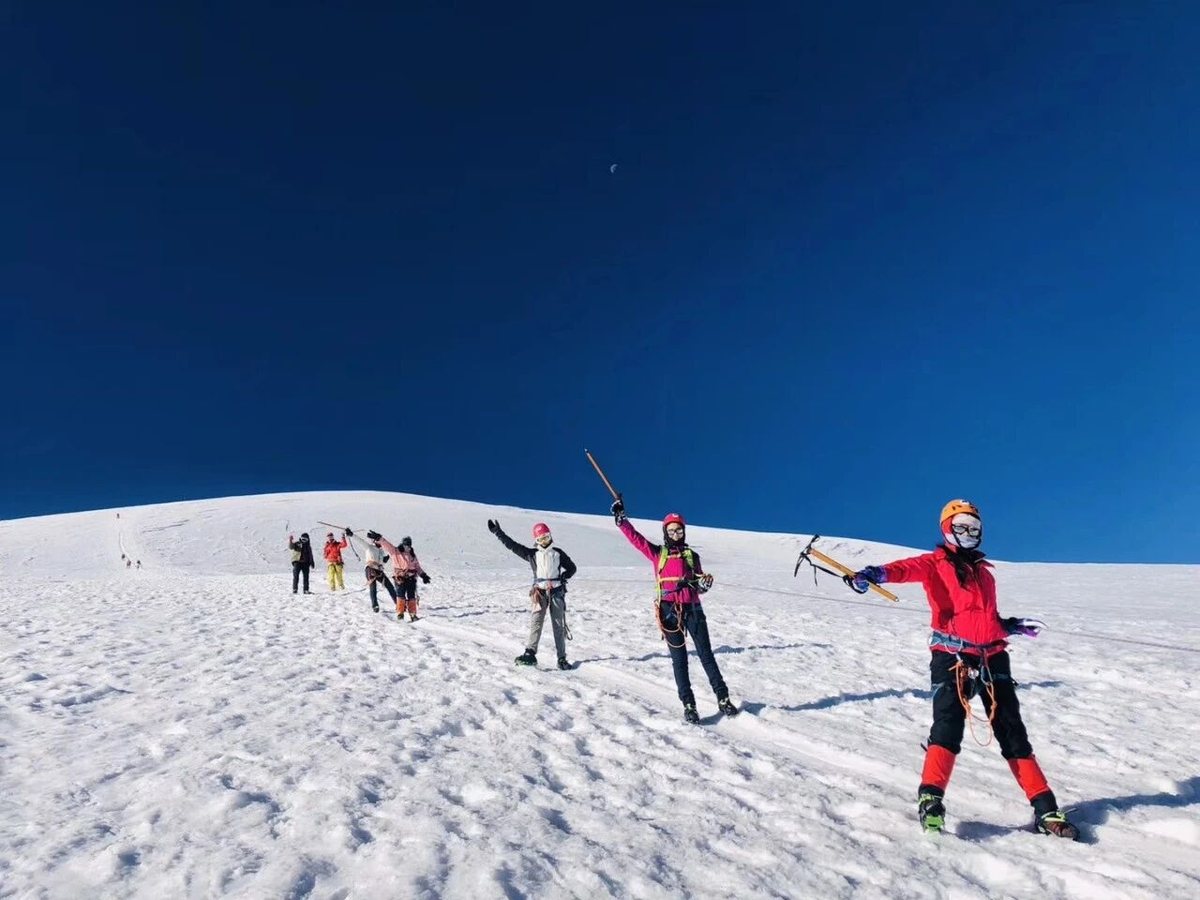 Hikers on a high snowfield, ice axes raised